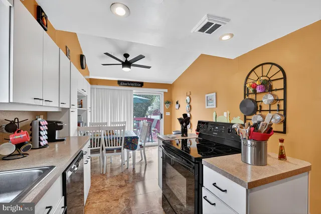 a kitchen with stainless steel appliances granite countertop a sink dishwasher and a stove with wooden floor