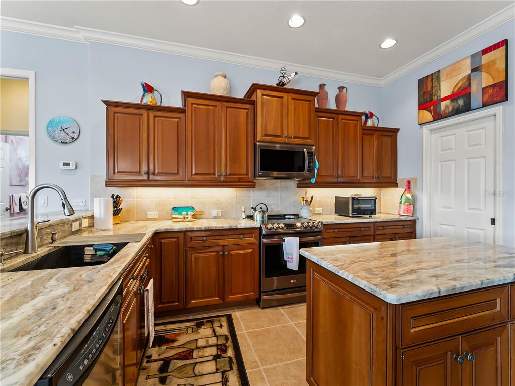 918 Chickadee Drive Venice, FL 34285 - Photo 27 of 85 a kitchen with stainless steel appliances granite countertop a sink stove and refrigerator
