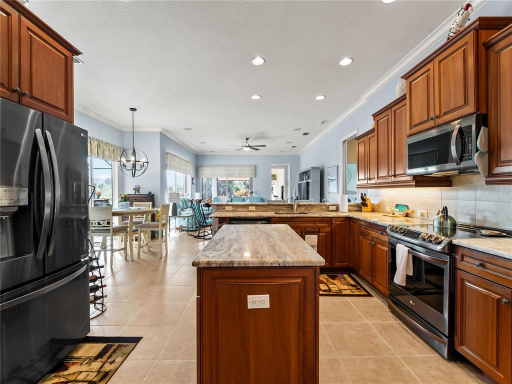 918 Chickadee Drive Venice, FL 34285 - Photo 29 of 85 a kitchen with stainless steel appliances granite countertop a stove a sink dishwasher a microwave oven with granite countertops and cabinets