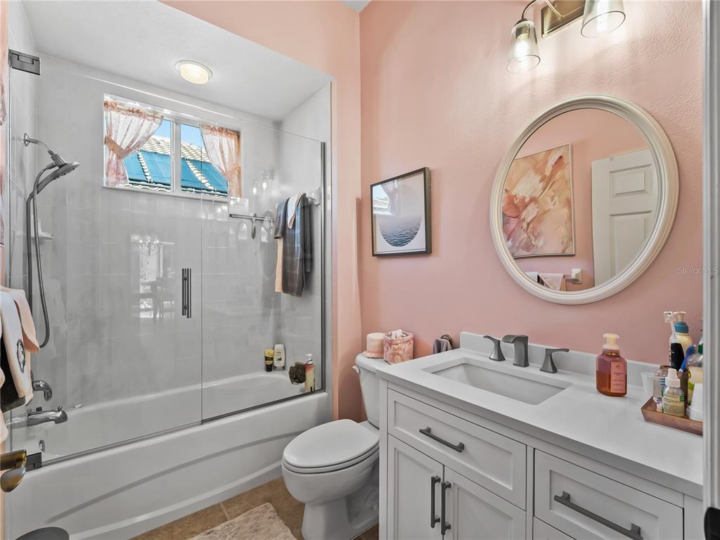 918 Chickadee Drive Venice, FL 34285 - Photo 38 of 85 a bathroom with a granite countertop toilet a sink and a mirror