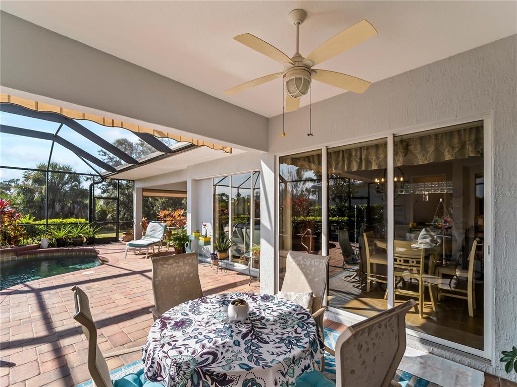 918 Chickadee Drive Venice, FL 34285 - Photo 48 of 85 a living room with furniture a floor to ceiling window and a flat screen tv