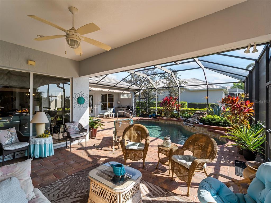 918 Chickadee Drive Venice, FL 34285 - Photo 54 of 85 a living room with patio furniture and a chandelier