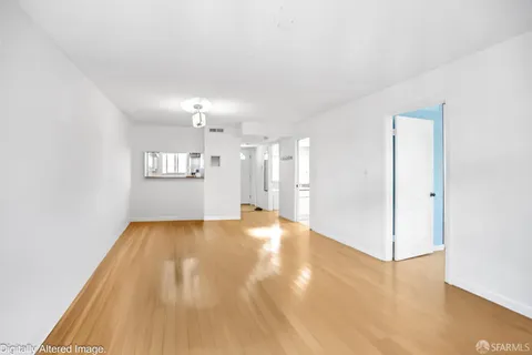 a view of empty room with wooden floor and windows