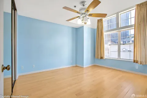 an empty room with windows and fan