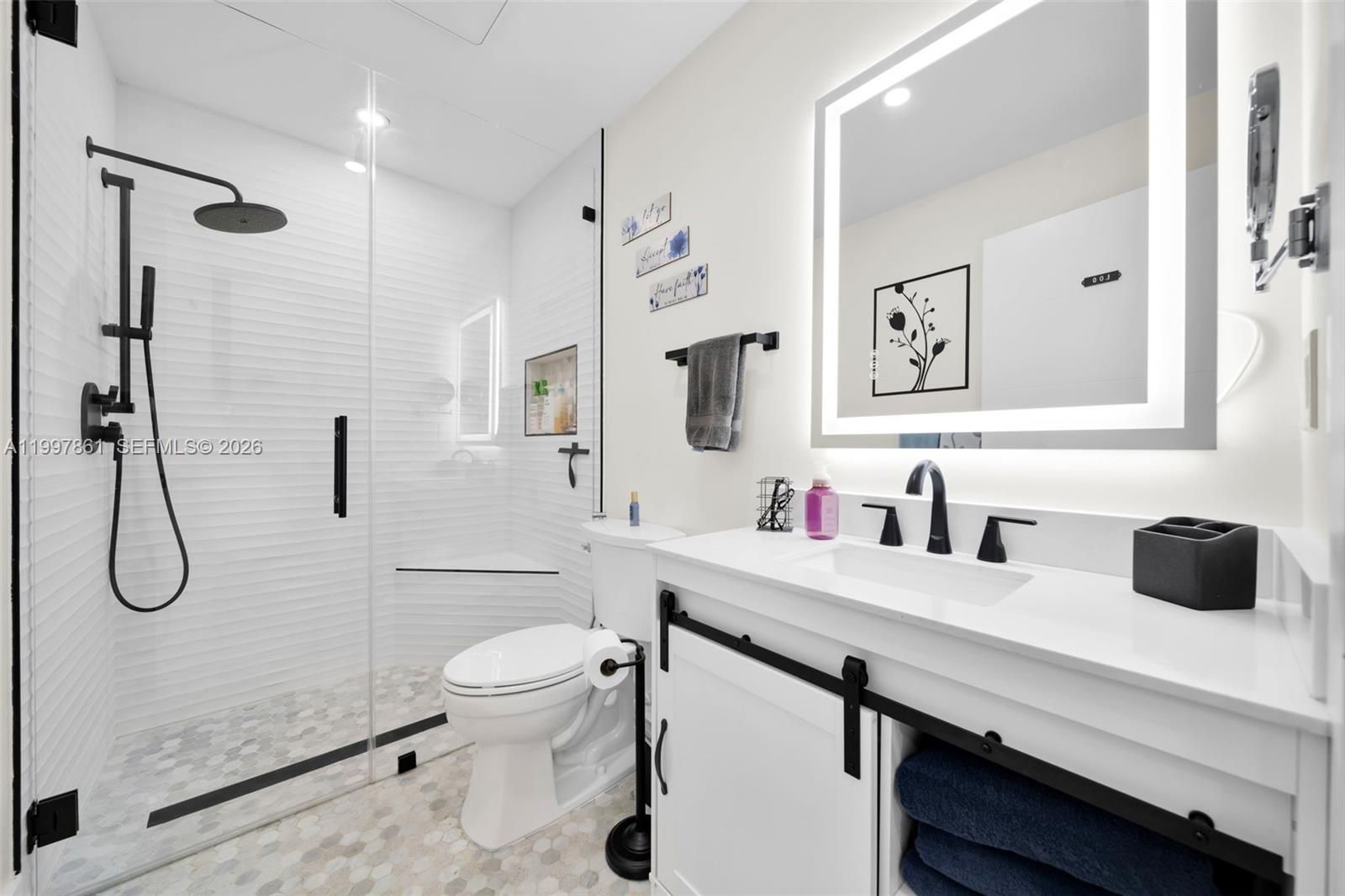1574 Ricardo Avenue Fort Myers, FL 33901 - Photo 17 of 59 a bathroom with a granite countertop sink a toilet and a large mirror