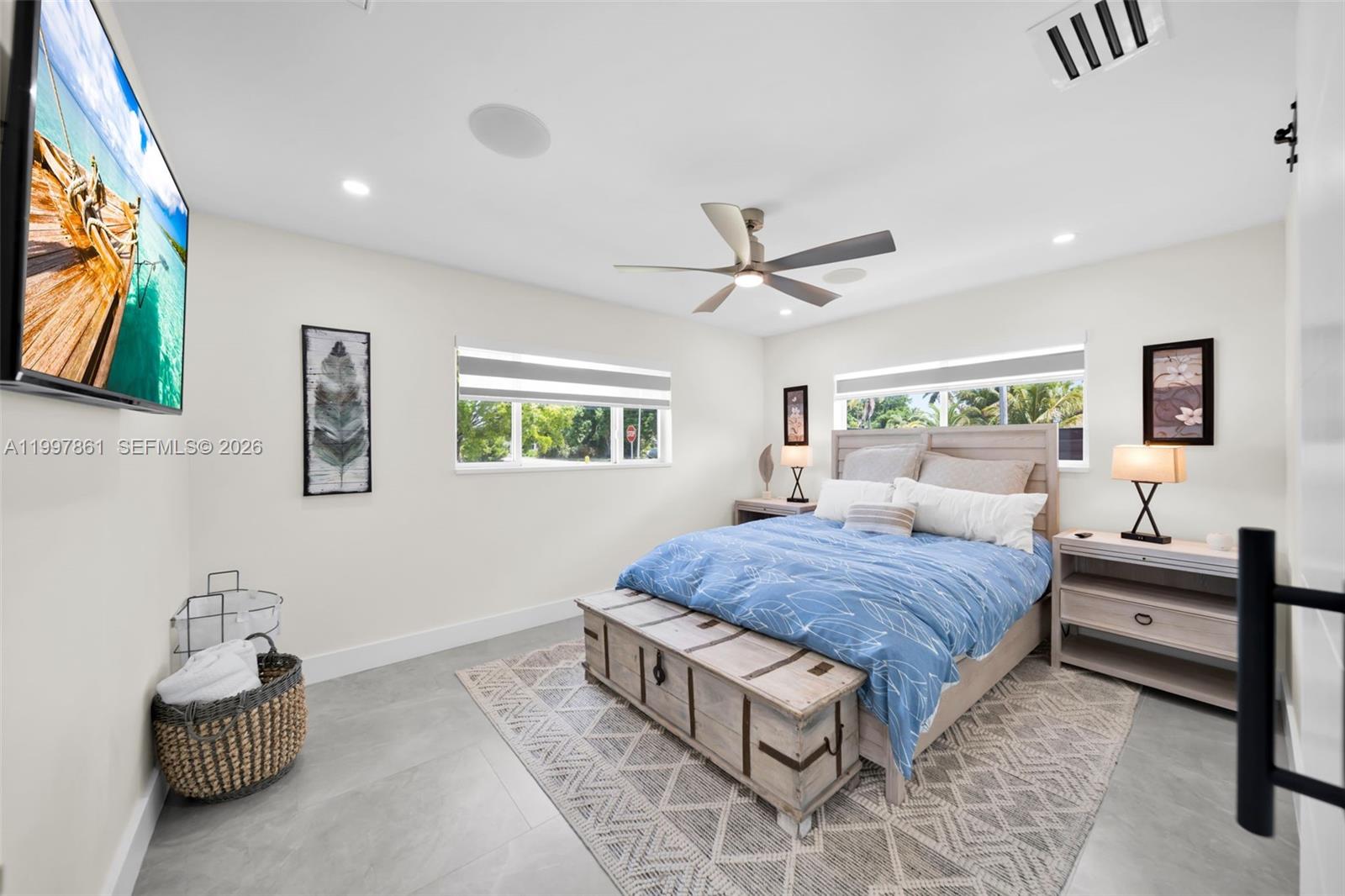 1574 Ricardo Avenue Fort Myers, FL 33901 - Photo 19 of 59 a spacious bedroom with a bed a couch and a flat screen tv