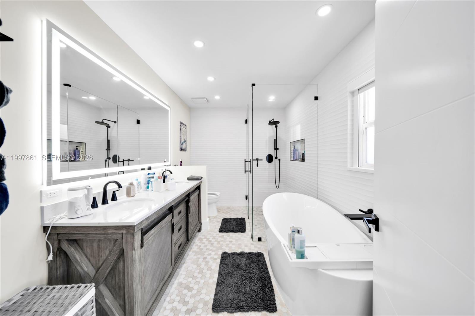 1574 Ricardo Avenue Fort Myers, FL 33901 - Photo 29 of 59 a bathroom with a tub double vanity sink and mirror