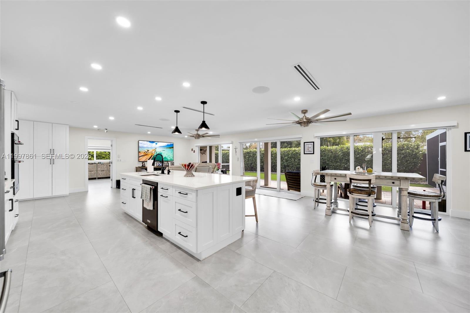 1574 Ricardo Avenue Fort Myers, FL 33901 - Photo 37 of 59 a large white kitchen with lots of counter space dining table and chairs