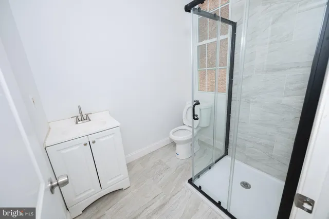 a bathroom with a sink a toilet and shower
