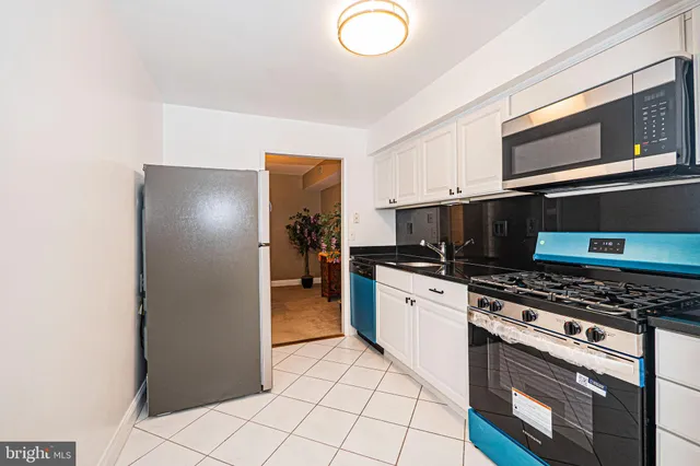 a kitchen with stainless steel appliances a stove microwave and refrigerator