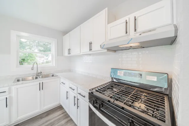a kitchen with white cabinets and appliances