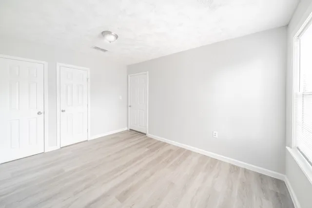 a view of an empty room with wooden floor