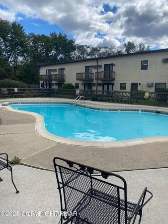 a view of a swimming pool with furniture