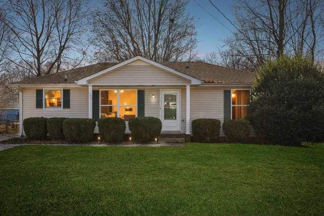 a front view of a house with a yard and trees