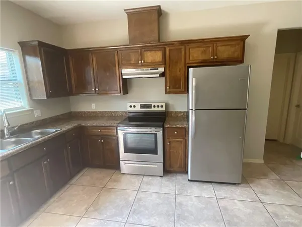 a kitchen with a sink a stove and a refrigerator
