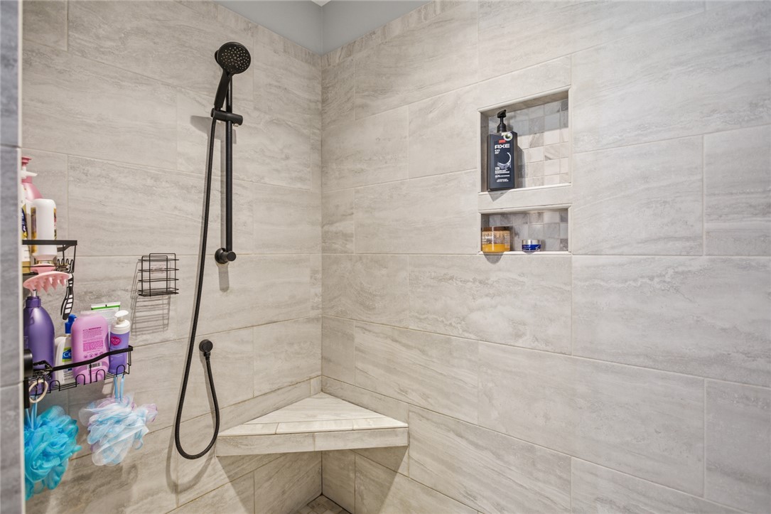 119 Brook Lane Seneca, SC 29672 - Photo 19 of 43 This tiled shower features convenient built-in niches and a corner bench for a relaxing bathing experience.