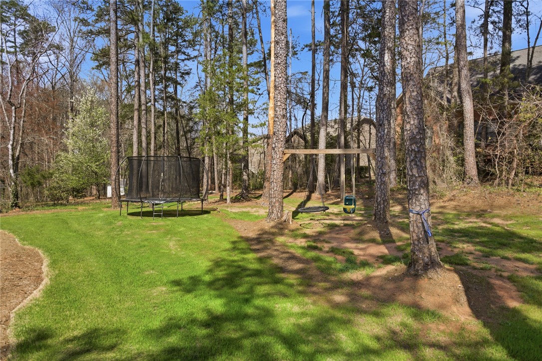 119 Brook Lane Seneca, SC 29672 - Photo 31 of 43 This verdant backyard offers ample space for recreation and relaxation, framed by mature trees.