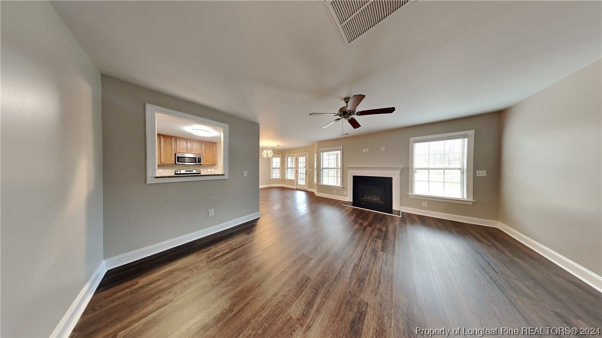 34 Huzzas Circle Cameron, NC 28326 - Photo 2 of 15 an empty room with wooden floor fireplace and windows