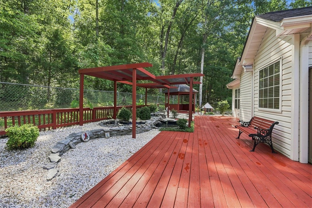1052 Madden Bridge Road Central, SC 29630 - Photo 40 of 50 An expansive wooden deck overlooks a gravel terrace with landscaped water features and a gazebo.