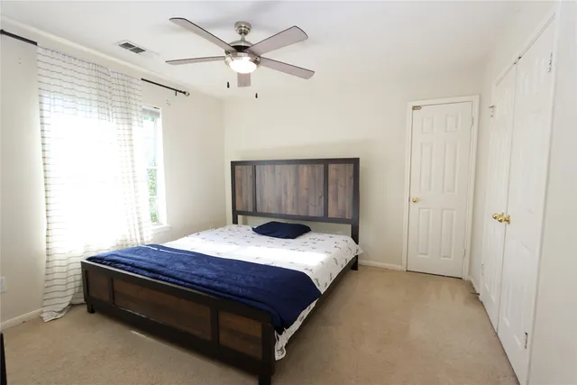 a spacious bedroom with a bed and a chandelier