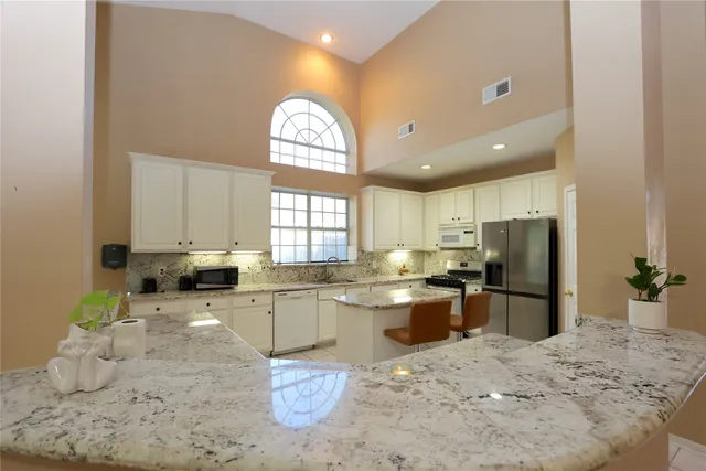 a kitchen with stainless steel appliances granite countertop a sink stove and refrigerator