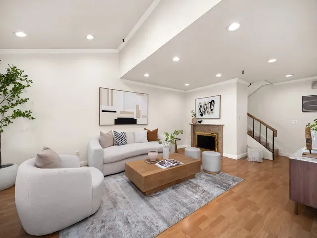 a living room with fireplace furniture and a potted plant