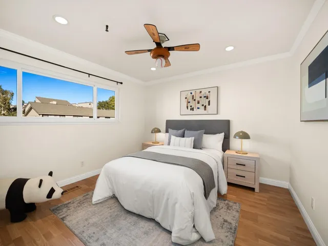 a bedroom with a bed and a ceiling fan