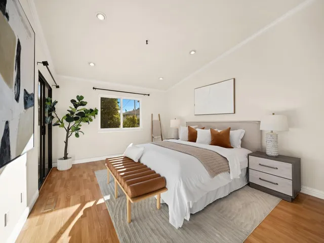 a bedroom with a large bed and a potted plant