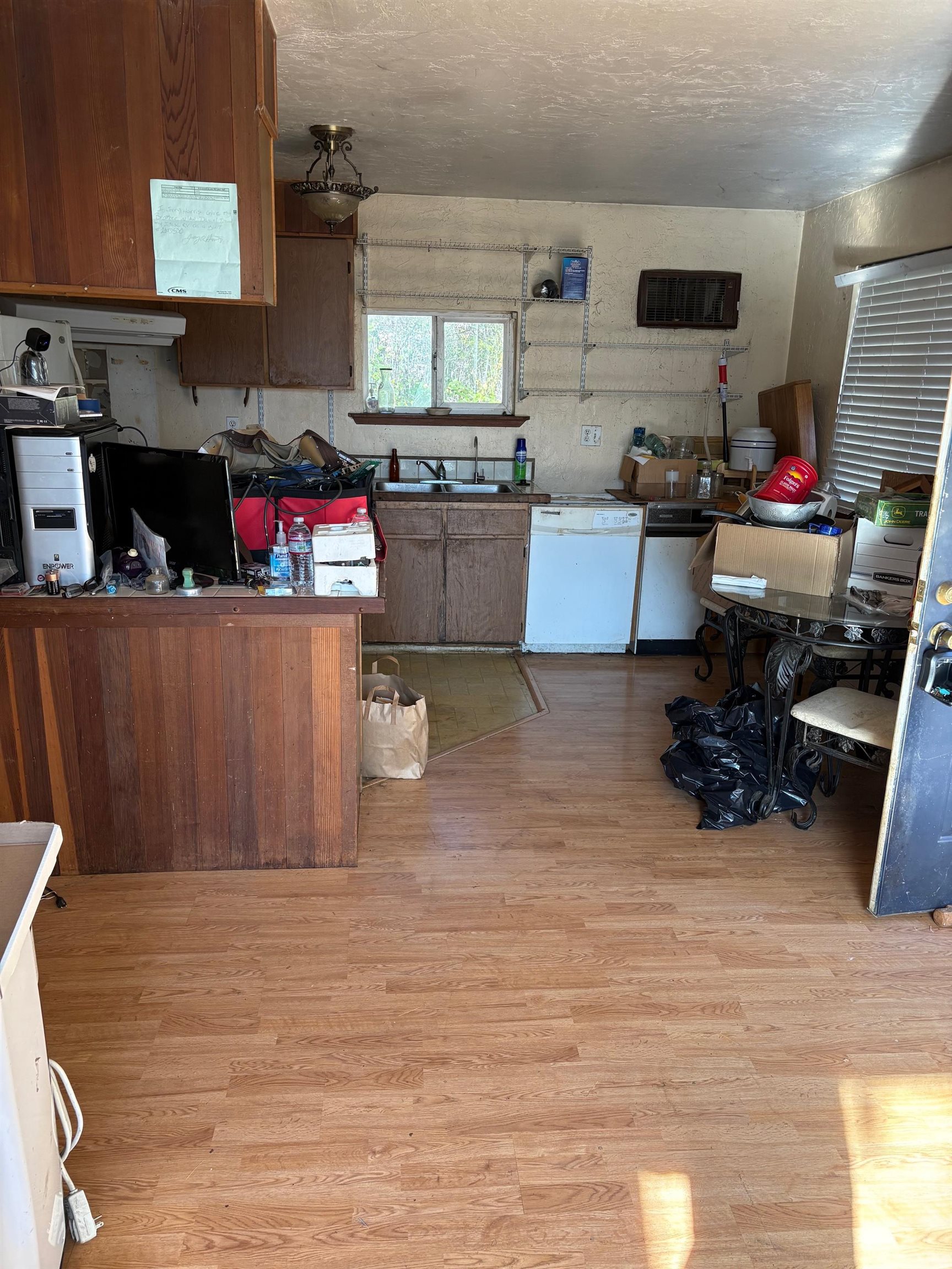 830 Shaws Flat Road Sonora, CA 95370 - Photo 5 of 11 Kitchen with brown cabinetry, dishwasher, light wood-style flooring, and dark countertops