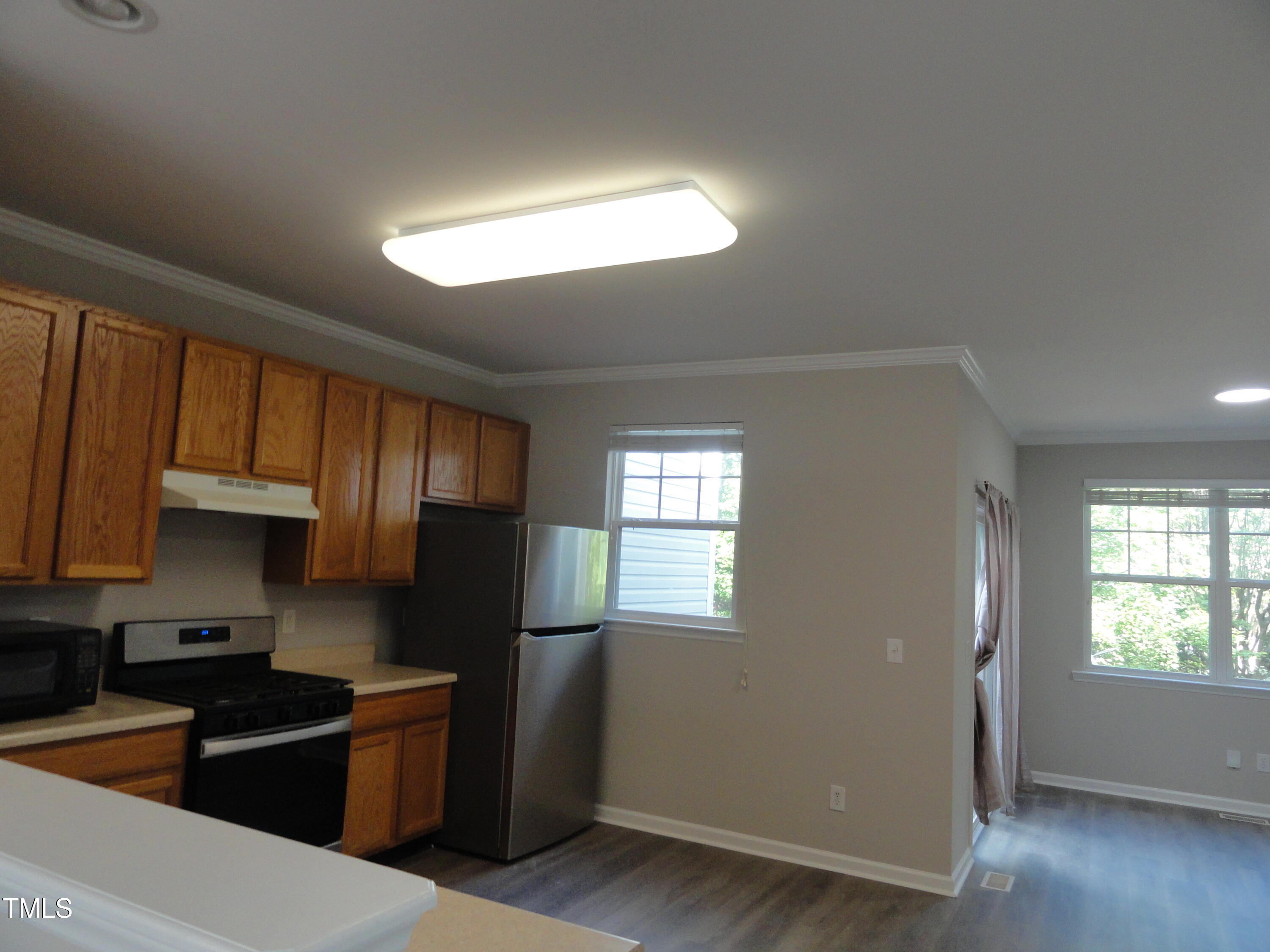 1531 Haywards Heath Lane Apex, NC 27502 - Photo 13 of 25 a kitchen with stainless steel appliances granite countertop a refrigerator a sink dishwasher a stove and white countertops with wooden floor