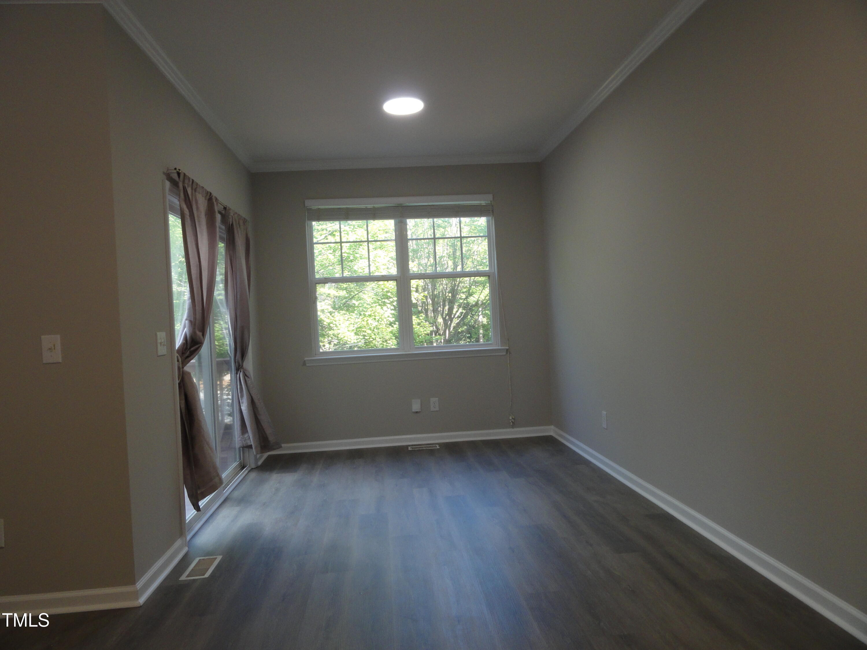 1531 Haywards Heath Lane Apex, NC 27502 - Photo 14 of 25 an empty room with wooden floor and windows