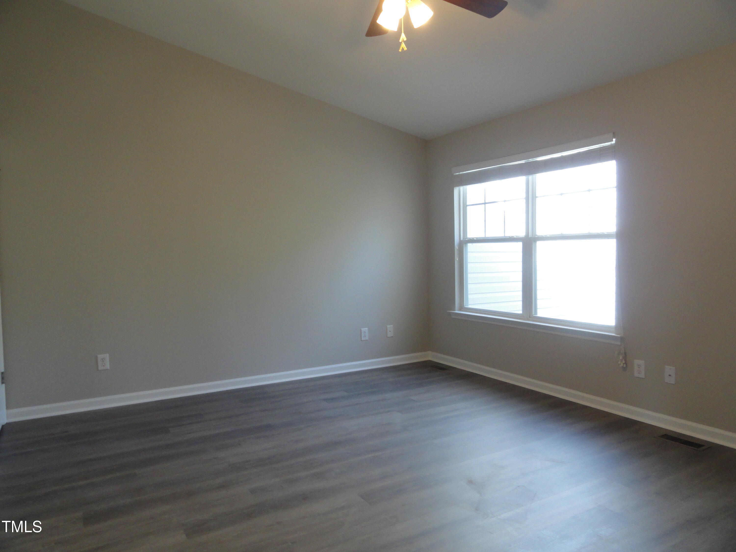 1531 Haywards Heath Lane Apex, NC 27502 - Photo 16 of 25 a view of an empty room with wooden floor and a window
