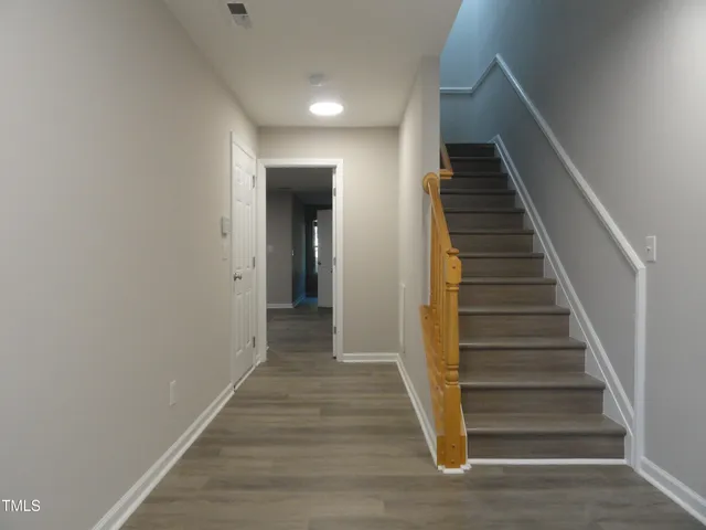 a view of a hallway with wooden floor and entryway
