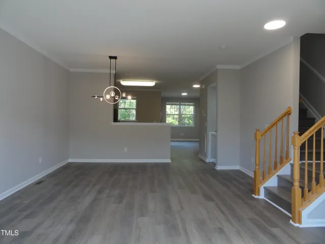 a view of a room with wooden floor fireplace and windows