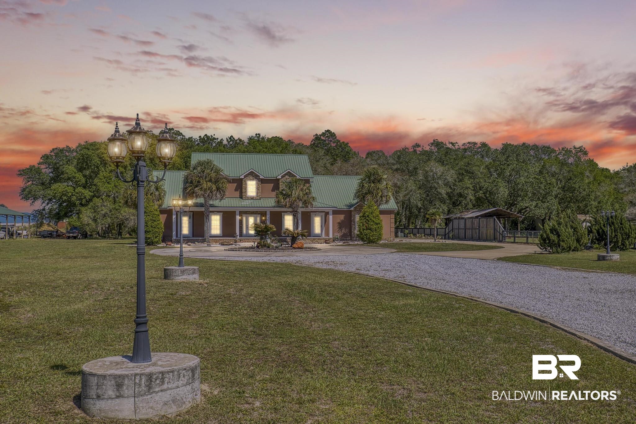 32875 Faircloth Road Lillian, AL 36549 - Photo 6 of 85 View of front of house with covered porch, a front yard, curved driveway, and a metal roof
