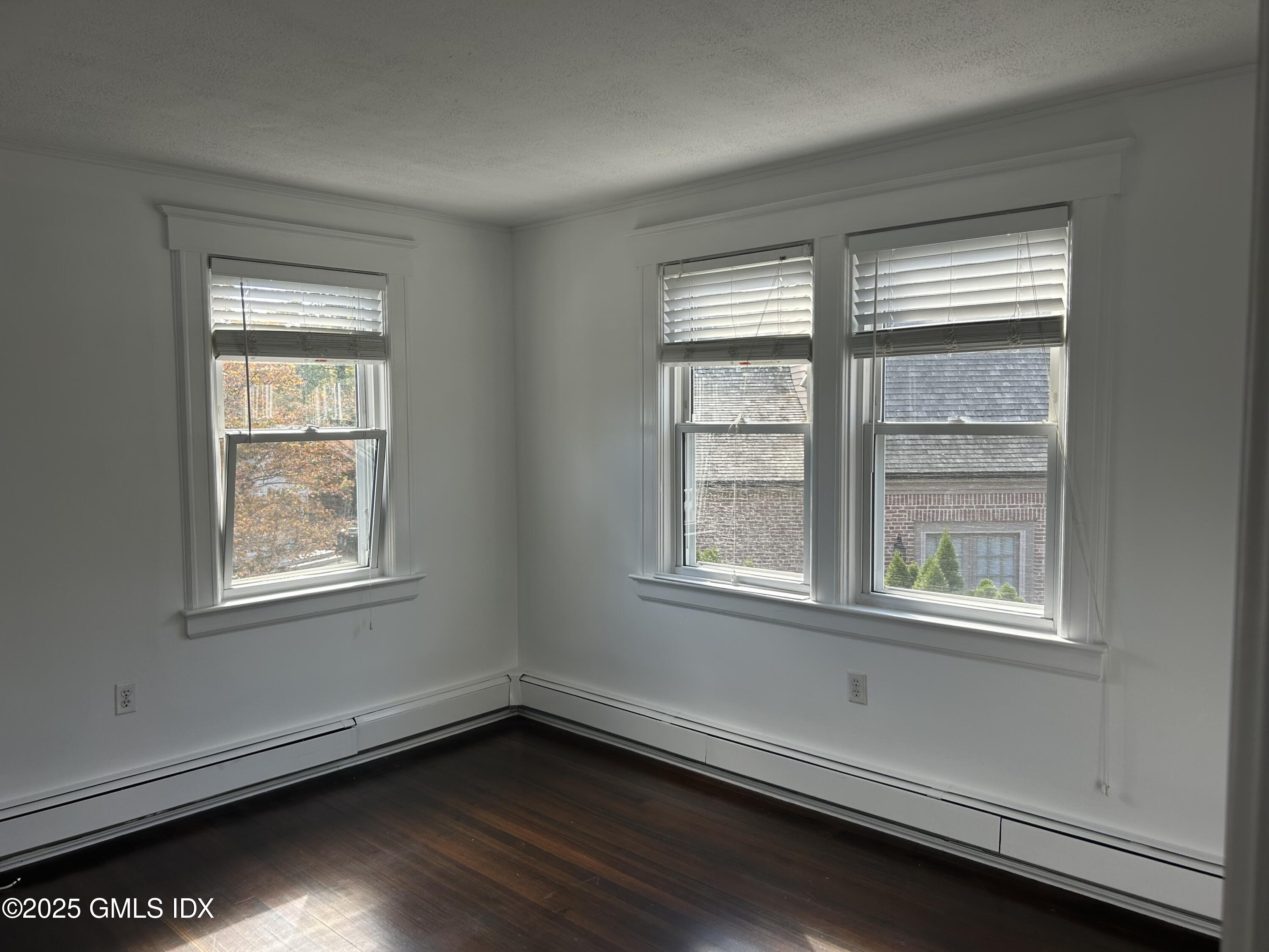 112 East Elm Street, Unit 1 Greenwich, CT 06830 - Photo 12 of 19 an empty room with wooden floor and windows