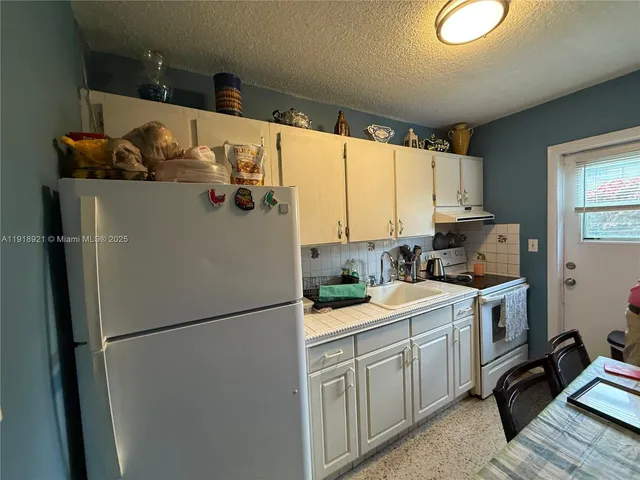 a kitchen with a refrigerator and a sink