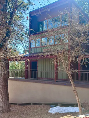 a view of a building with a small yard and a large tree