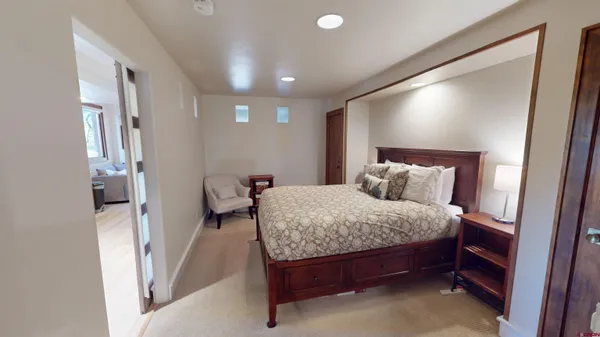 a bedroom with a bed and a flat tv screen on wall
