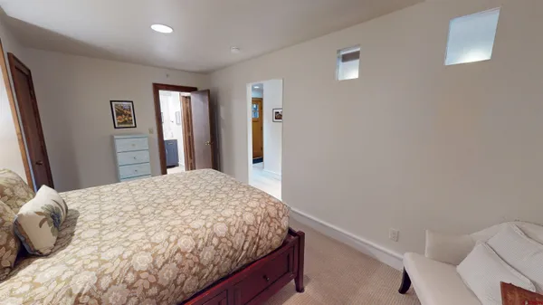 a bedroom with a bed and a dresser with rug