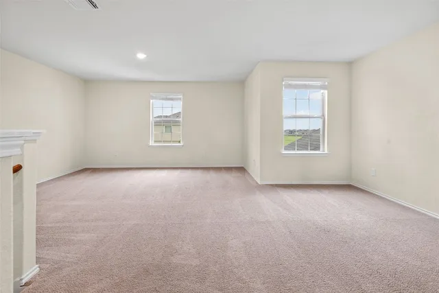 a view of a big room with windows and chandelier fan