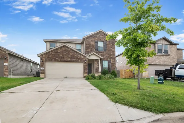 a front view of a house with a yard and garage