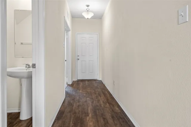 a view of a hallway with wooden floor and closet