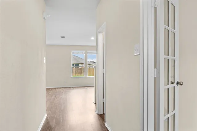 a view of a hallway with wooden floor