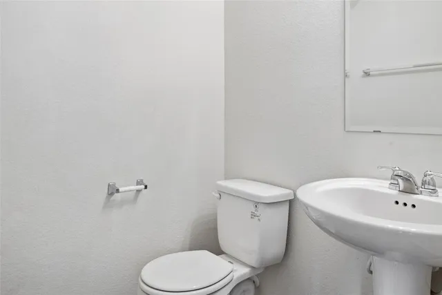 a white toilet sitting next to a white sink