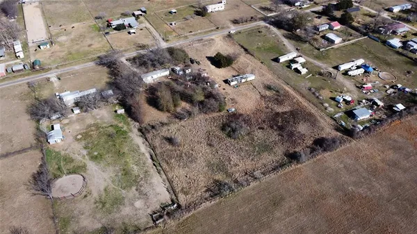 a view of a dry yard with trees