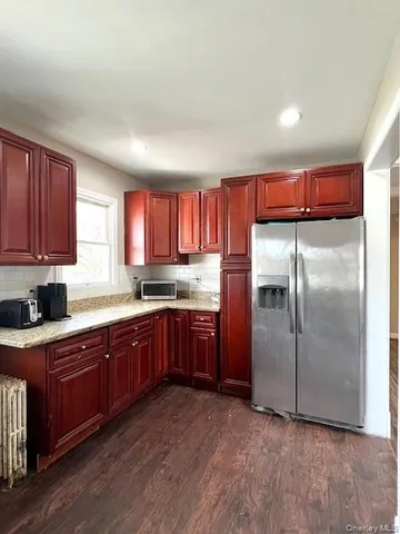 a kitchen with stainless steel appliances granite countertop a refrigerator a sink dishwasher a stove with wooden cabinets and floor