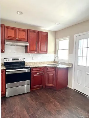 a kitchen with granite countertop wooden cabinets and stainless steel appliances