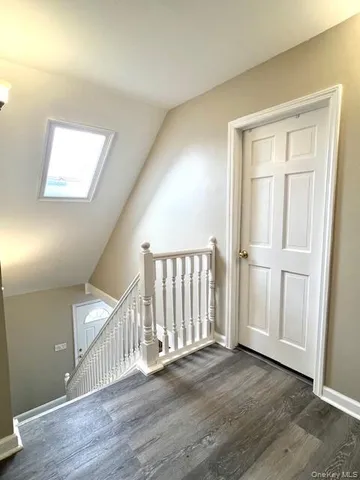 an empty room with wooden floor & windows