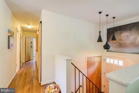 a view of a hallway with wooden floor and staircase